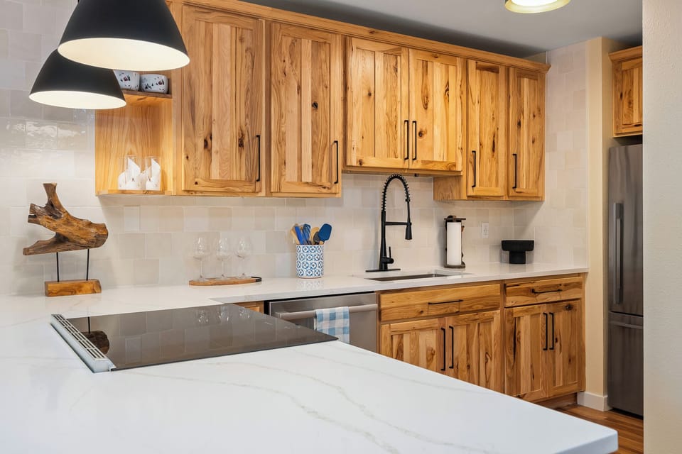 Your fully equipped kitchen features warm wood cabinets, modern appliances, and marble countertops perfect for preparing memorable meals.