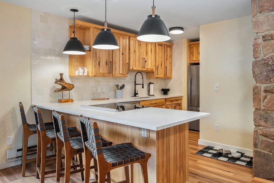 Your modern kitchen welcomes you with warm wood cabinetry, sleek pendant lighting, and a spacious island perfect for morning coffee or evening gatherings.