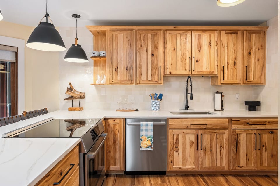 Your fully equipped kitchen features warm wood cabinetry, modern appliances, and bright pendant lighting - perfect for preparing memorable meals together.