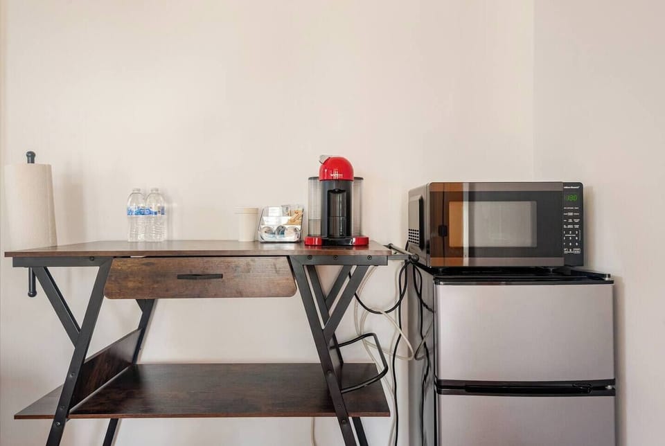 Fully stocked amenities station with coffee maker, compact fridge, and microwave