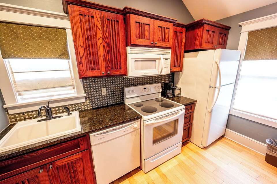 Prep favorite meals beneath warm wood cabinetry and sleek backsplash