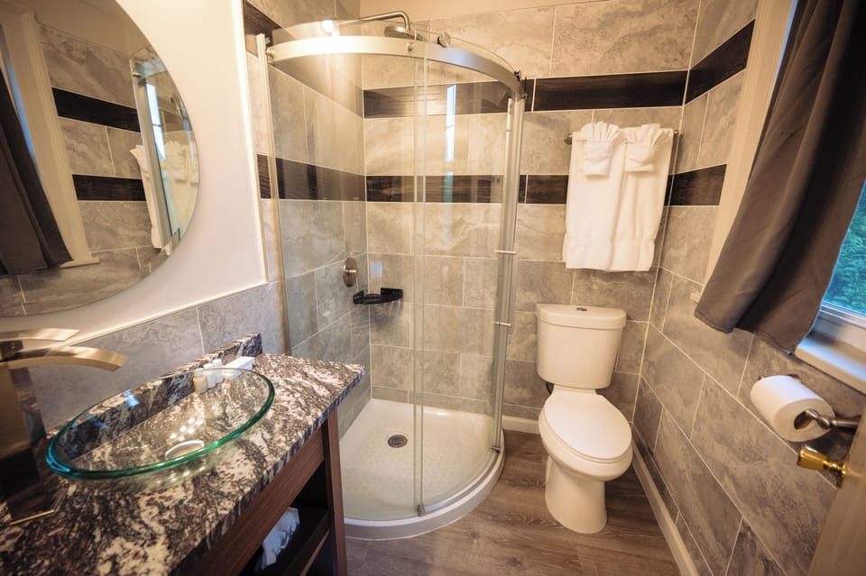 Refresh in a sleek shower with fresh towels and granite vanity