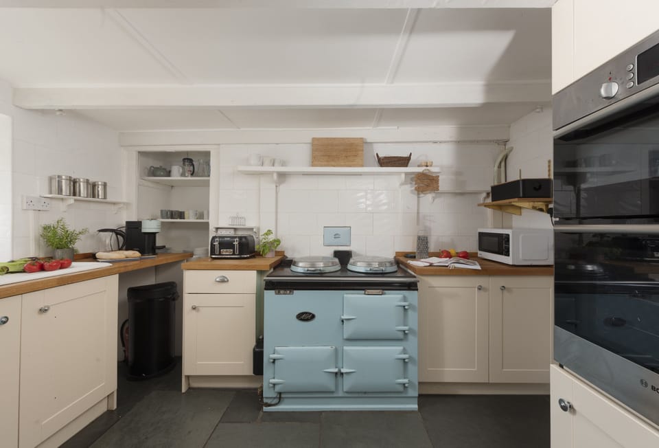 Primrose Cottage, Treyarnon Bay: The open-plan country kitchen welcomes you with a traditional AGA