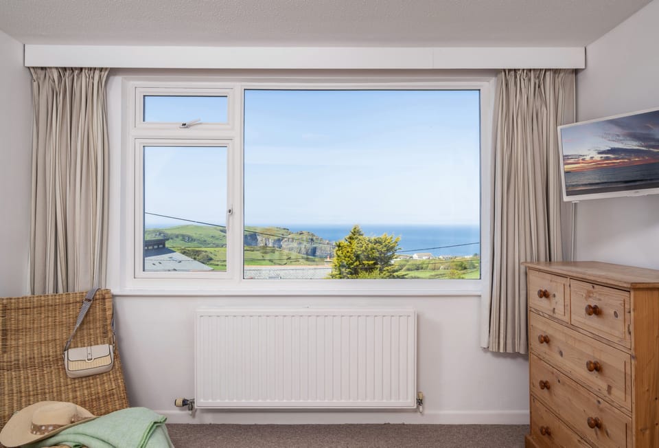 Boskenna, Tintagel: King-size bedroom with large windows perfectly framing the spectacular view
