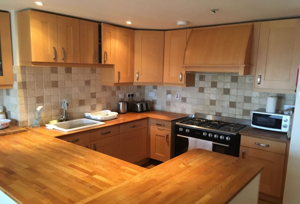 Surfside, Mawgan Porth. First floor: A traditional kitchen with a warm, homely feel, ideal for preparing tasty meals with family or friends.