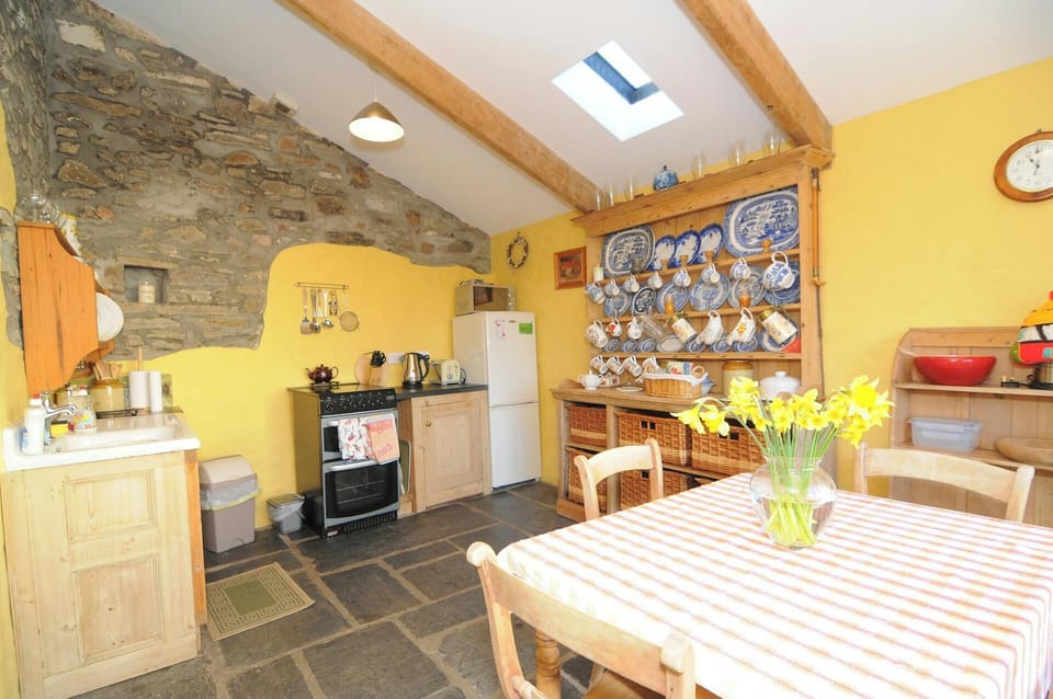 Country kitchen: cooker, fridge/freezer, kettle, toaster, microwave, sink, dining table andchairs