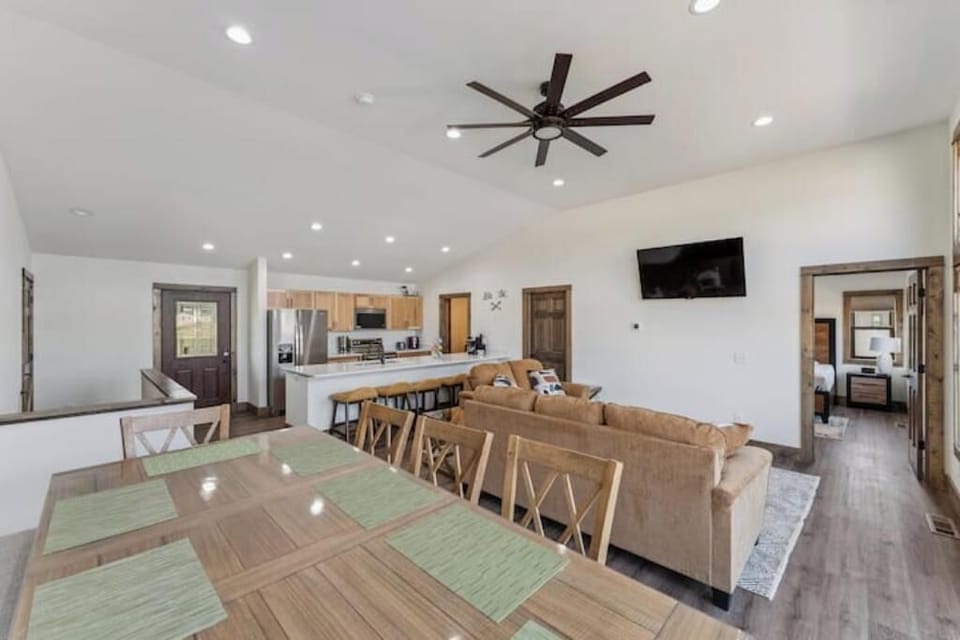 Upstairs main living area has dining table, couch, love seat, bar stools, kitche