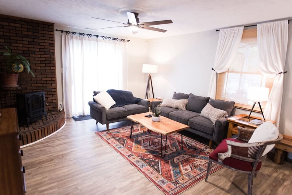 The living room has a desk and sliding glass door with an abundance of light.