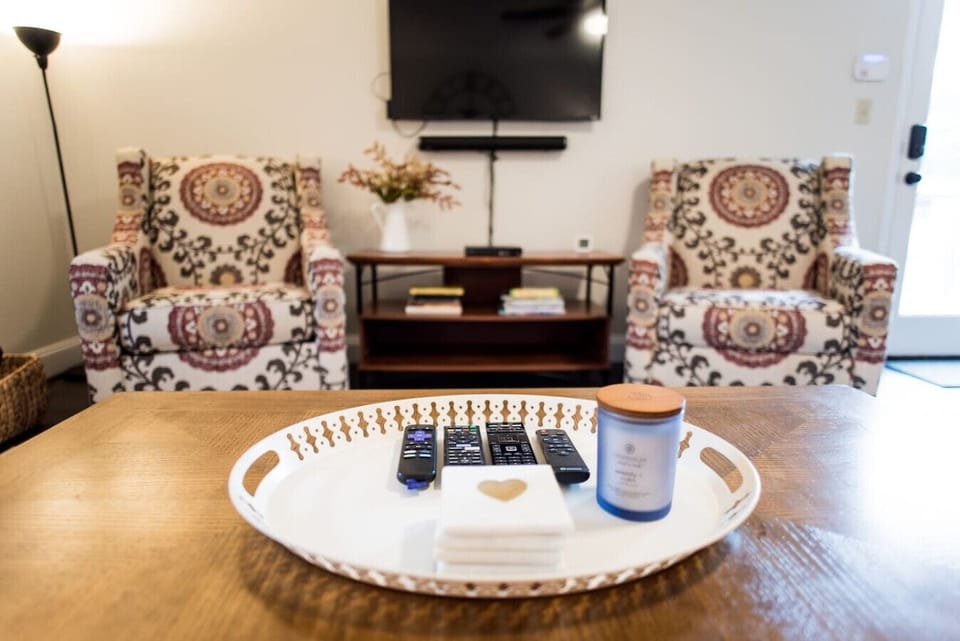 Living room with TV, Bose surround speaker, twin pull out bed, and natural lighting.
