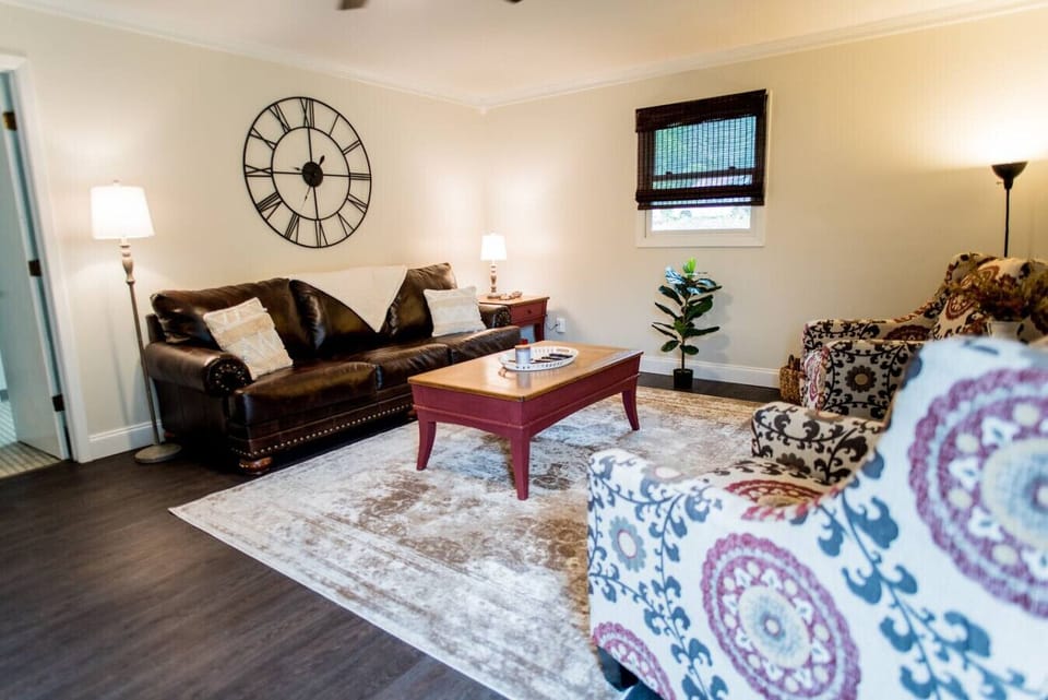 Living room with TV, Bose surround speaker, twin pull out bed, and natural lighting.