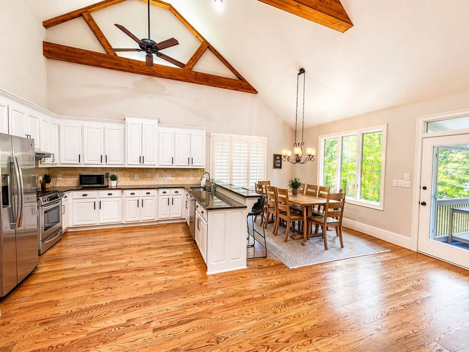 Bright open kitchen and dining area with vaulted ceilings, large island seating, and space for the whole group to gather.