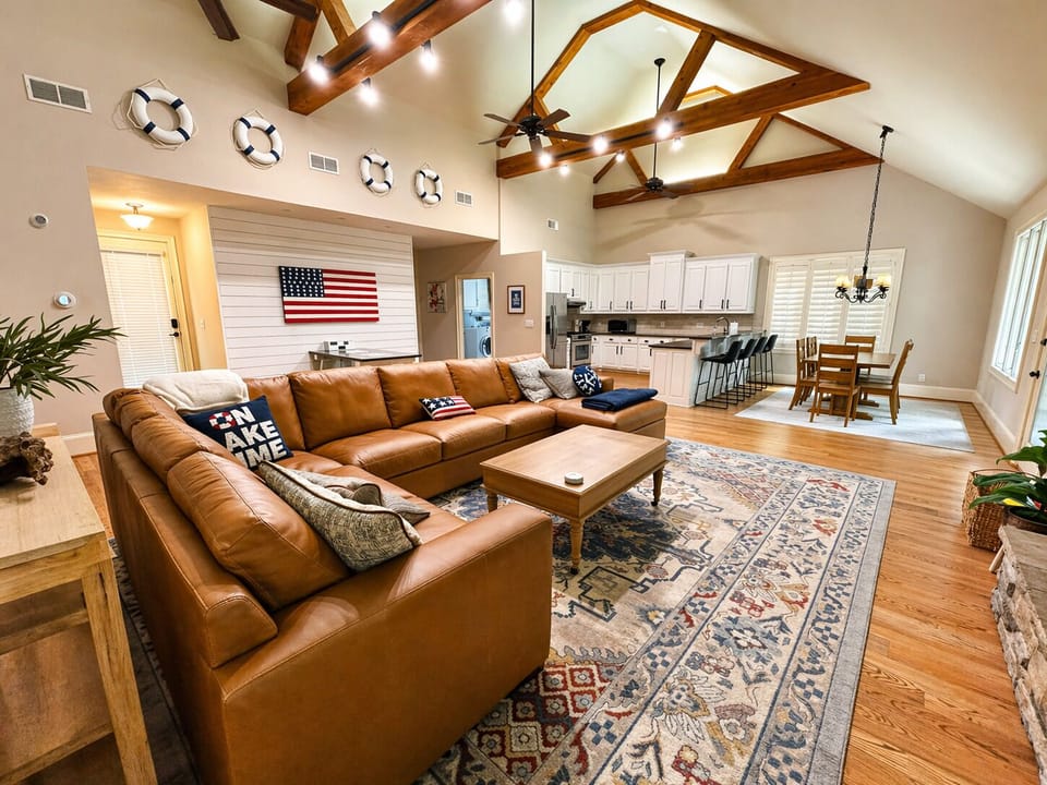 Cozy up in the spacious great room with soaring ceilings, a stone fireplace, and plenty of room for everyone to relax after a day on Lake Lanier.