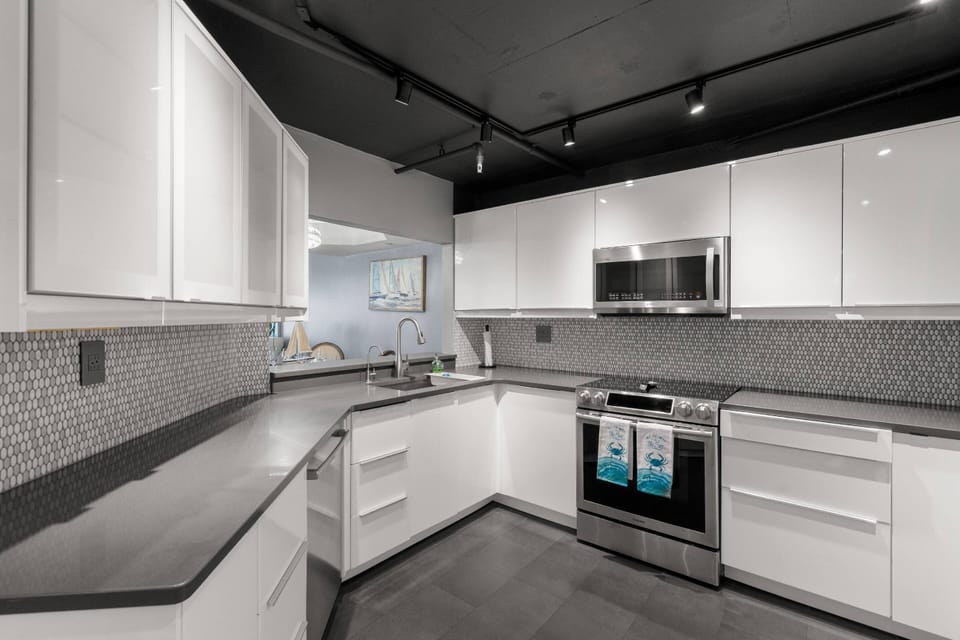 Updated, Fully Equipped Kitchen with Sleek White Cabinets and Stainless-Steel Appliances
