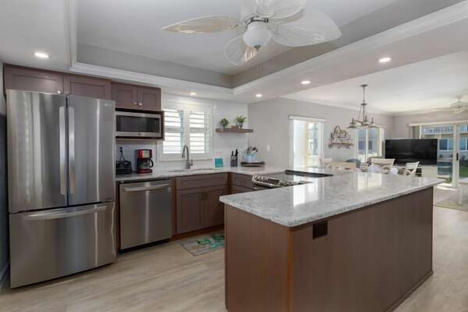 Enjoy cooking in this modern beachside kitchen with stainless steel appliances, granite countertops, and open layout—perfect for preparing meals after a day by the ocean.