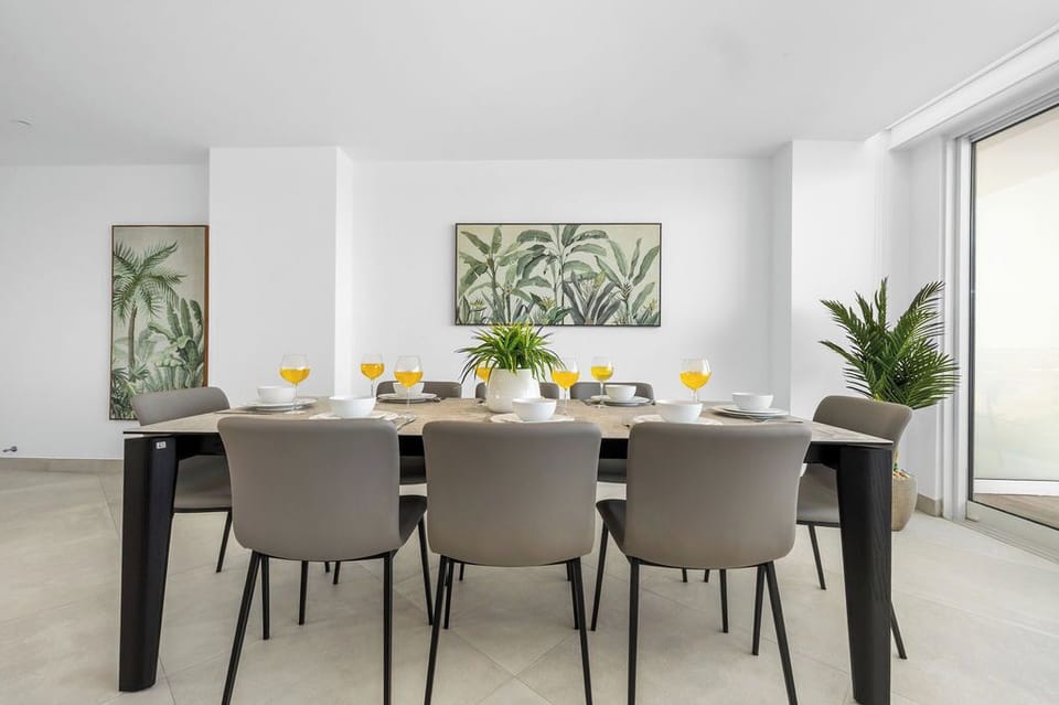 Gather around this bright dining space, where botanical art and modern design set the stage for your vacation meals together.