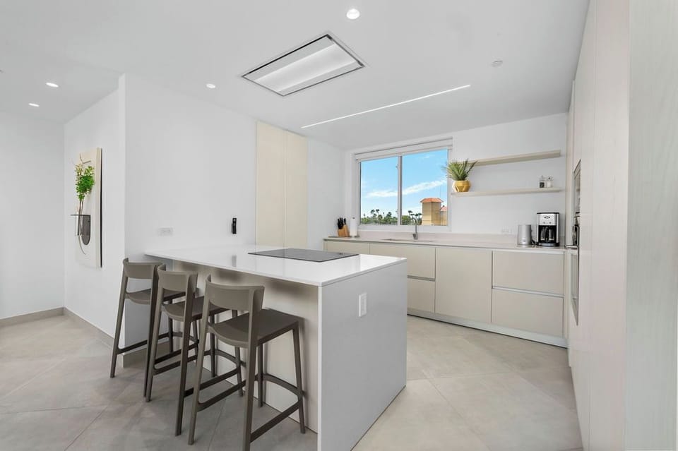 Your sleek, sun-filled kitchen features modern appliances and a convenient island with seating—perfect for whipping up meals and sharing stories with loved ones.