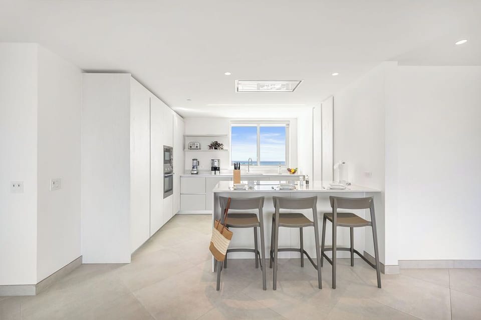Picture yourself preparing meals in this bright, modern kitchen with sleek countertops, stainless steel appliances, and a breakfast bar where you can enjoy your morning coffee while gazing at stunning ocean views.