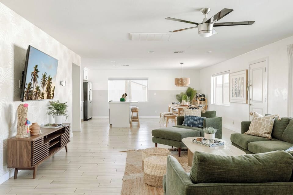 Bright and inviting living room with two sofas, a cozy chair and ottoman, and plenty of space to gather. The smart TV and open-concept layout make it perfect for movie nights or catching up after exploring Old Town Scottsdale.