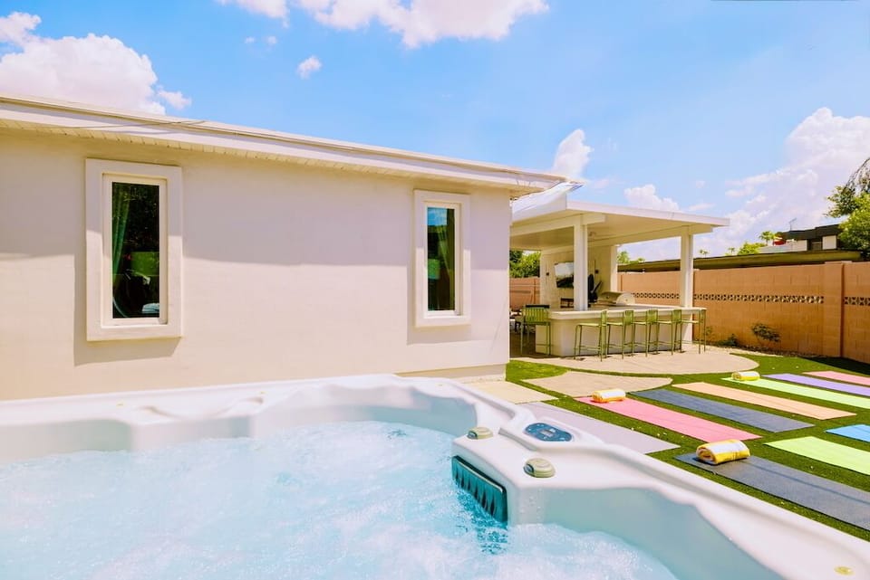 Backyard oasis with hot tub, yoga lawn, and covered bar seating