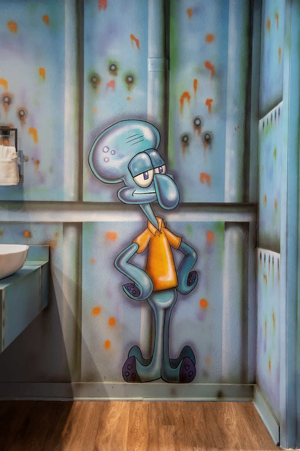 A playful mural of a cartoon character adds a unique touch to this modern bathroom corner.