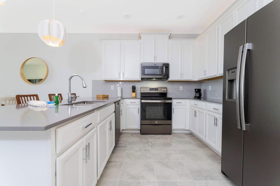 The heart of the home! This modern kitchen is fully equipped with stainless steel appliances and a large island, ideal for preparing family meals.