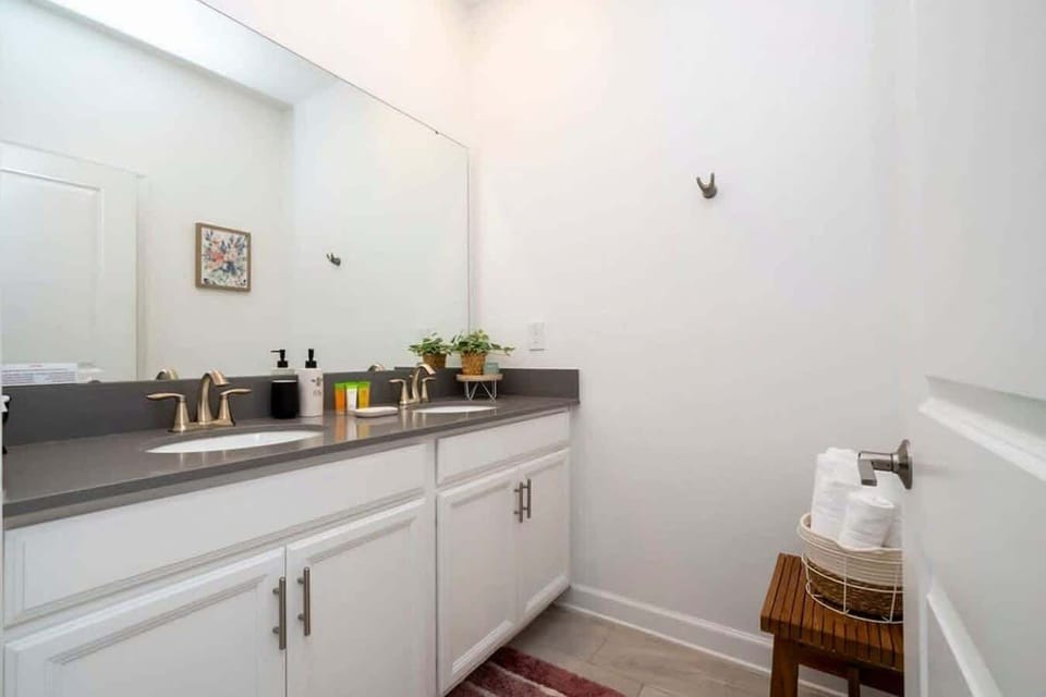 Refresh in style in this modern bathroom with dual sinks, sleek fixtures, and plenty of space-ideal for sharing and starting your day with ease.