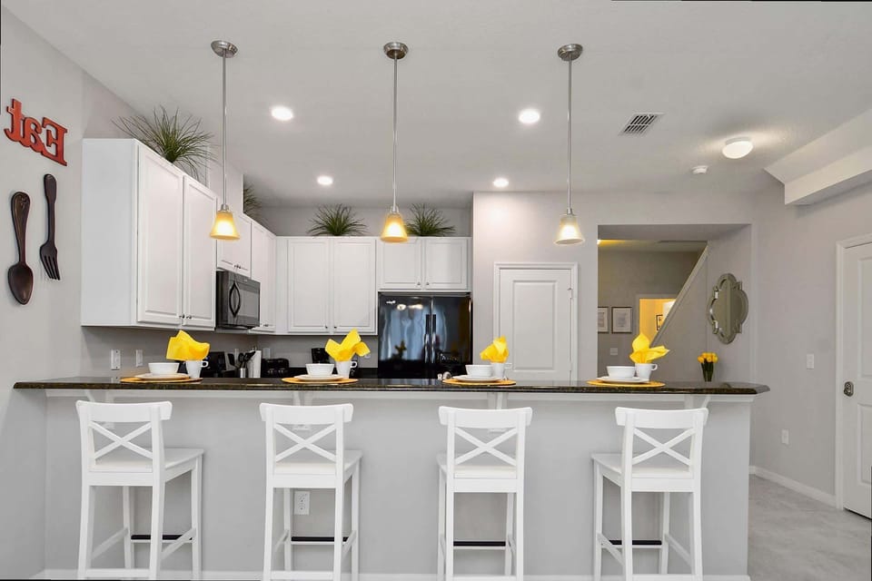 Marvel at the kitchen’s modern three-pendant lighting, crisp white cabinets, and plenty of counter space for all your culinary creations.