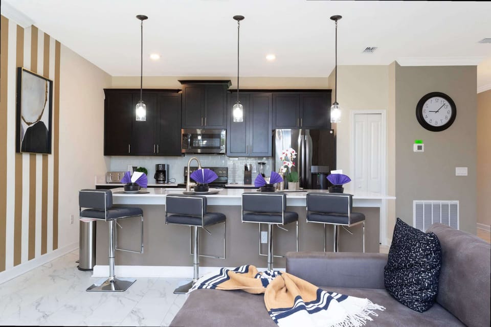 Sip your morning coffee at the chic island bar with seating for four, sleek black cabinetry, stainless steel appliances, and stylish pendant lights-modern comfort meets gourmet convenience!