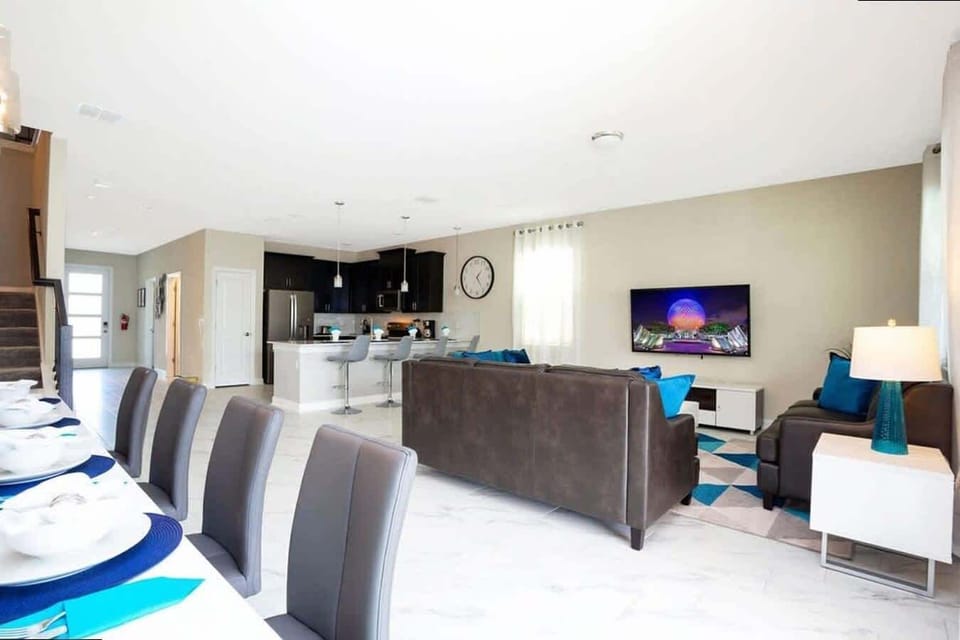 Celebrate togetherness in this airy open-concept space: dine at the chic table, relax on the sleek leather sofa with teal accents, or whip up snacks at the quartz island with bar seating-modern style meets family fun!