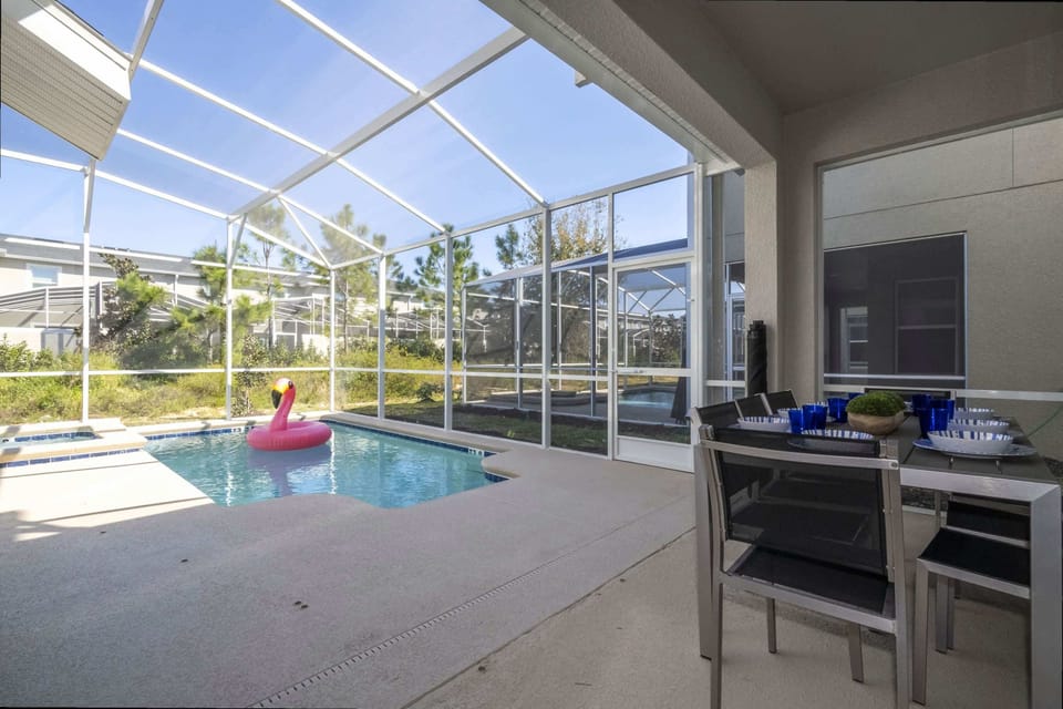 Enjoy poolside dining and fun in this screened patio, featuring a modern outdoor table and a sparkling pool just steps away!