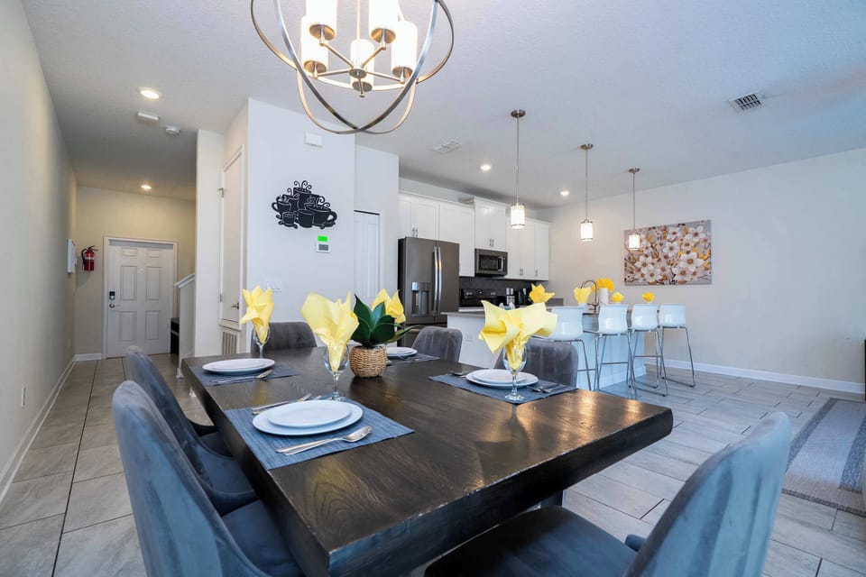 Dine in style with this elegant table setting, contemporary chairs, and open sightlines to the modern kitchen and living space-ideal for group gatherings.