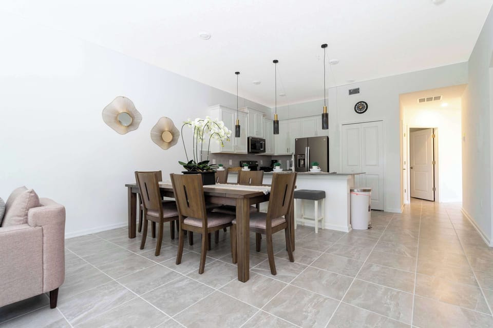 Contemporary dining next to a chef-ready kitchen-pendant lighting, stainless appliances, and a handy breakfast bar for two.