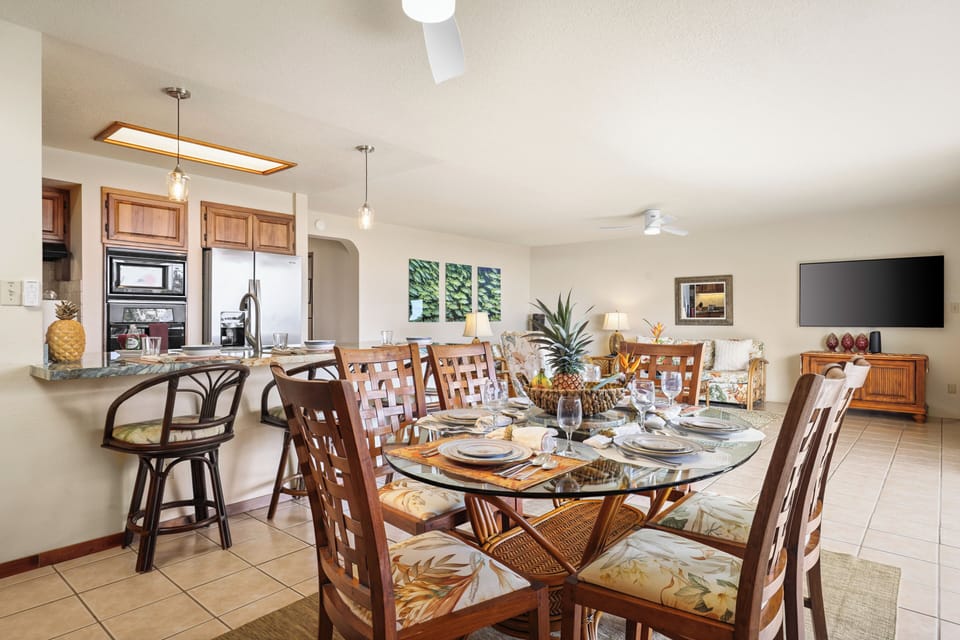 Spacious open-concept living and dining area - This bright, breezy space features tropical dining for six, a fully equipped kitchen with bar seating, and a cozy living area with island-style decor and a large, smart TV