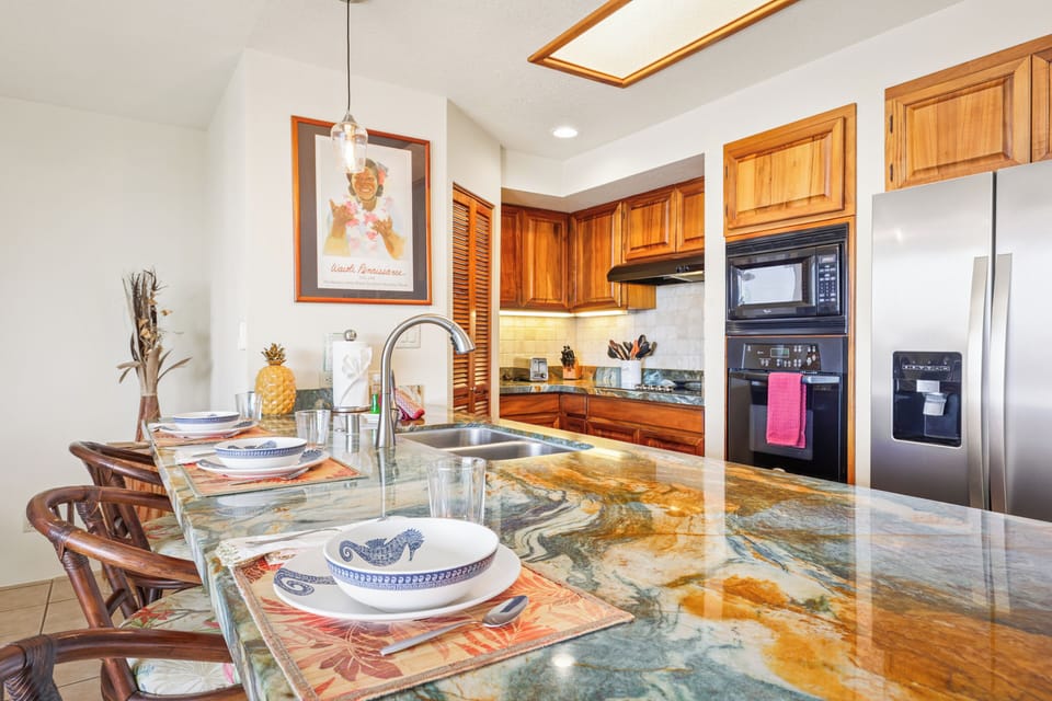 Gorgeous granite kitchen with island seating - This vibrant kitchen features striking granite countertops, warm wood cabinetry, and a full suite of appliances. Bar seating makes it easy to gather, dine, or chat while cooking.