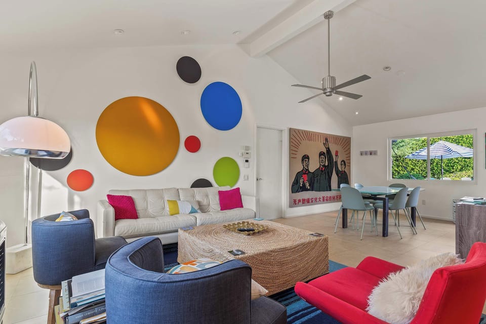 Playful modern living room with colorful wall art & cozy seating. 
