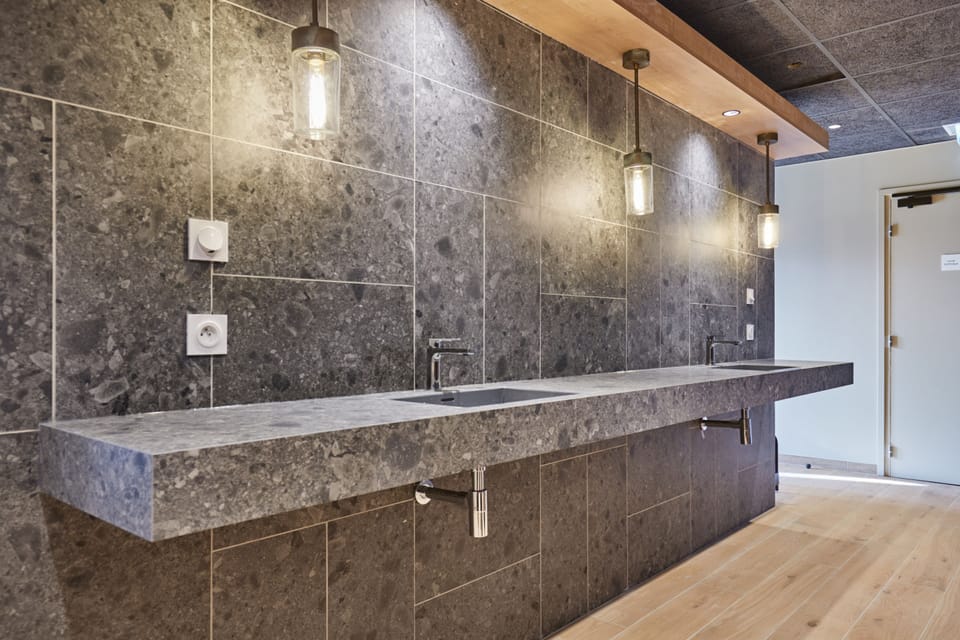 Stone vanity counter with two pendant lights — part of the spa changing facilities available on-site.