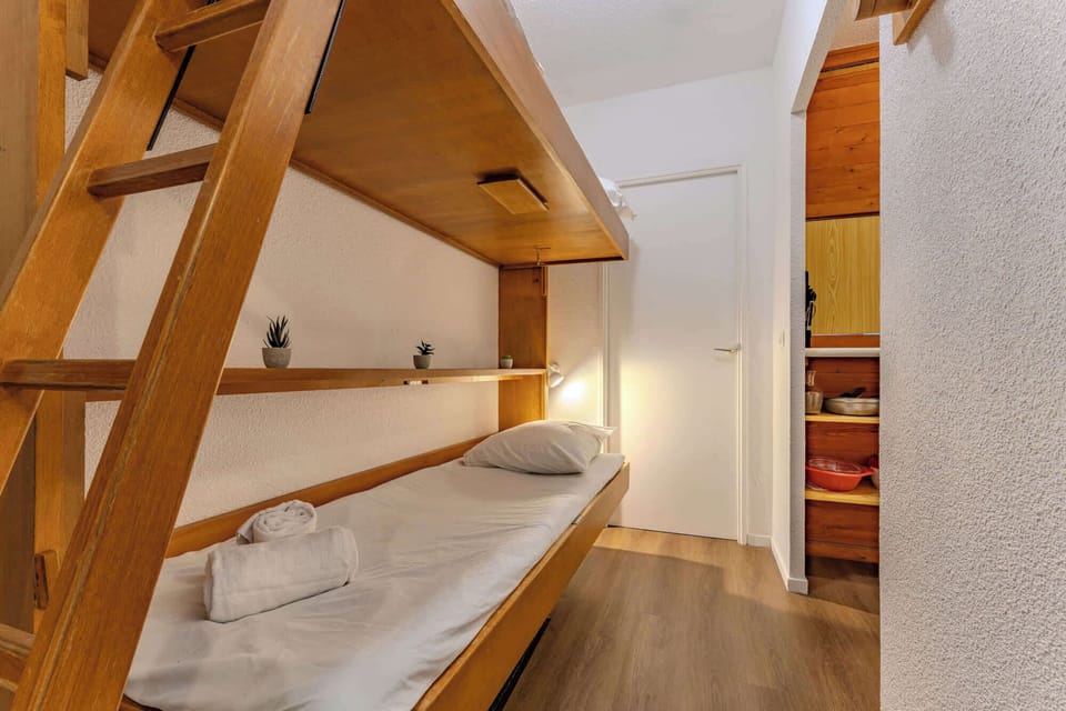 Alpine-style sleeping nook with solid wood bunk beds—perfect for kids or friends sharing a mountain escape in Val Thorens.