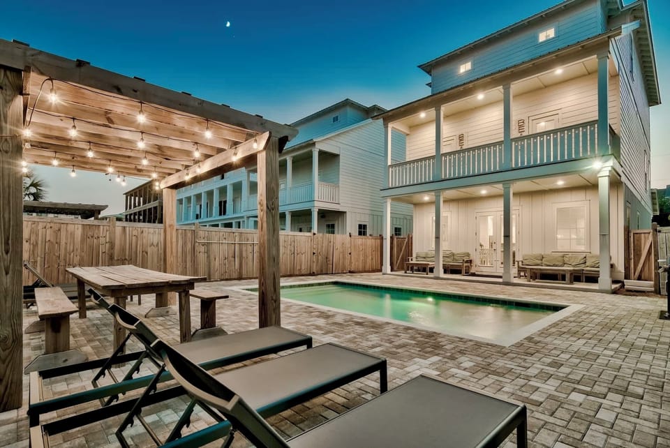 Escape to your private backyard oasis featuring a heated pool, plenty of lounge chairs for soaking up the sun, corn hole, and a covered porch with lounge seating. Dine alfresco at the outdoor dining table or grill out with the gas grill.