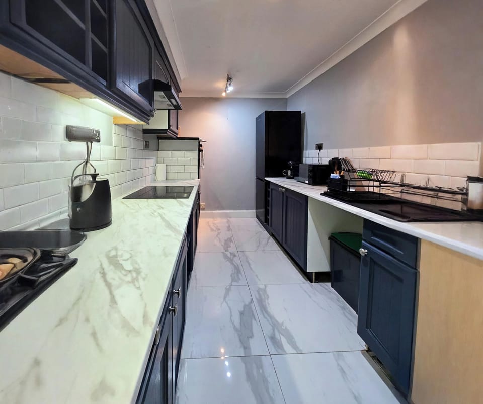 Kitchen with washing mobile, fridge freezer and microwave.