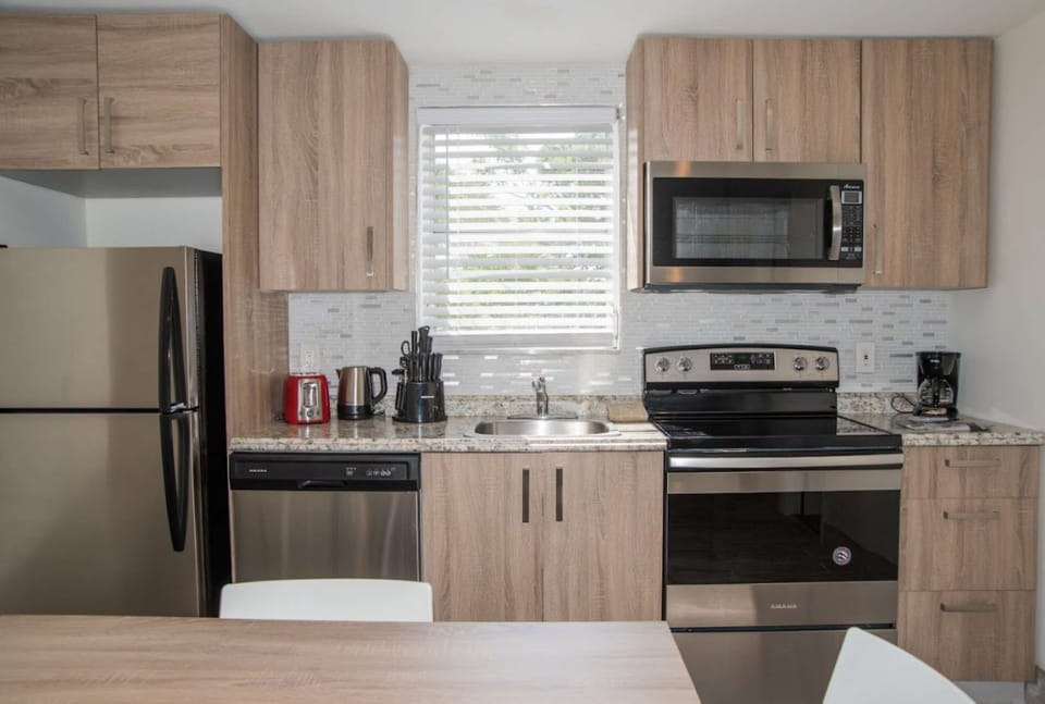 Kitchen with cabinets, fridge, stove, microwave, and counter