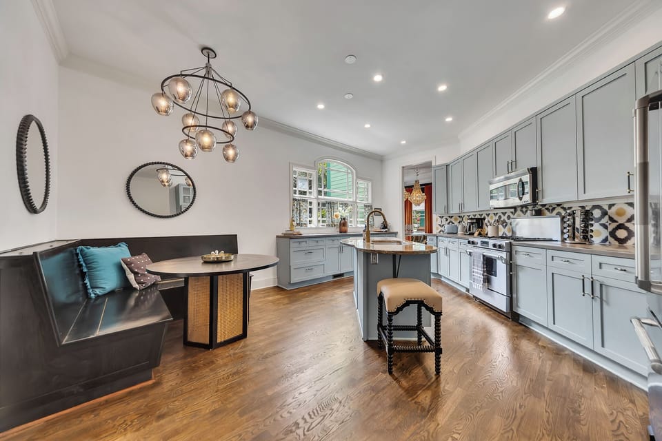  The main kitchen area features extensive floor-to-ceiling cabinets painted a distinct