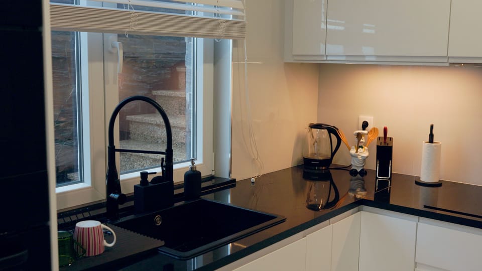 A modern, fully furnished kitchen featuring Zimbabwe Black granite worktops. 