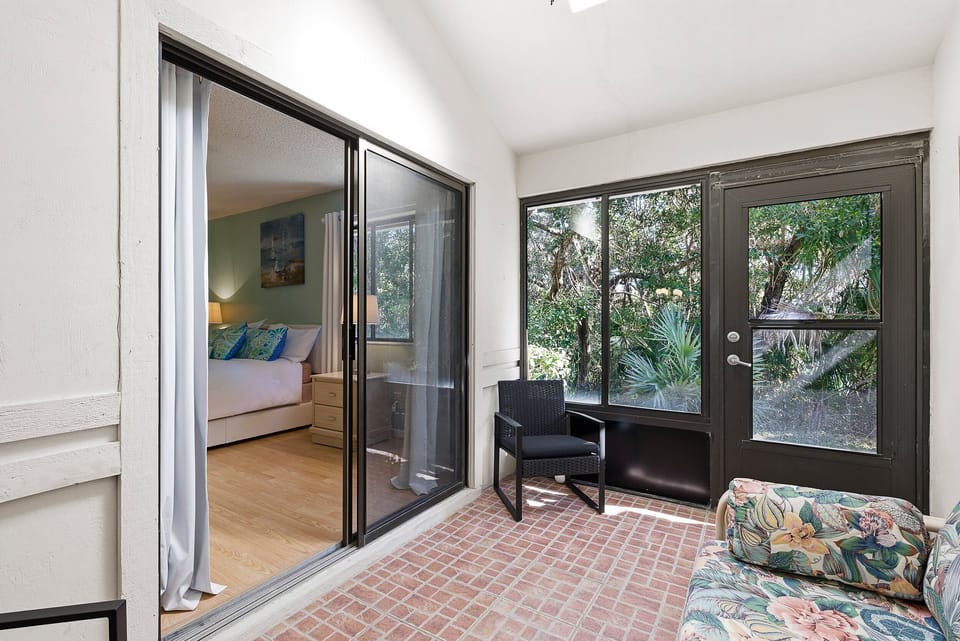 Enjoy tranquil garden views from this private patio with cozy seating and direct bedroom access. A serene spot to sip coffee or unwind after a sunny day during your relaxing and memorable beach stay getaway.