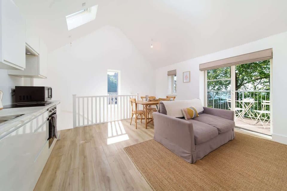The Tree Top apartment’s bright living room offers a light-filled space to relax, unwind, and enjoy the treetop views.