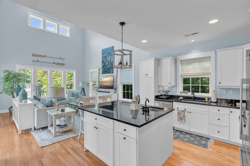 Your open-concept retreat blends modern kitchen elegance with cozy living comfort, bathed in natural light from generous windows.