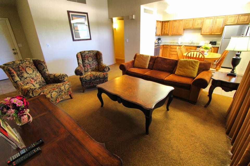 Open living area with wall-mounted TV and cushioned sofa seating for winding down after the trails