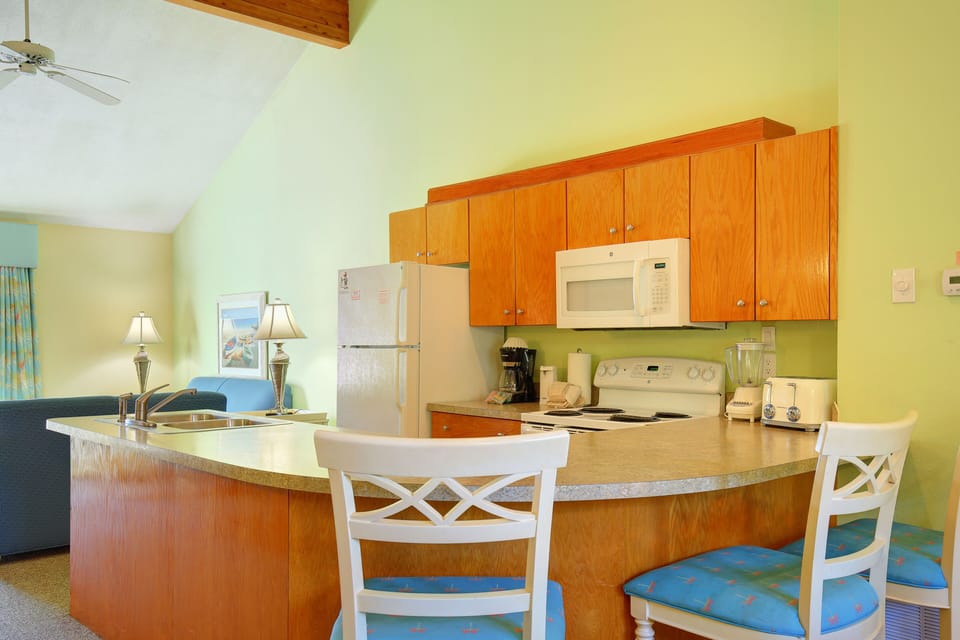 With its spacious layout and cheerful decor, this kitchen is the heart of the condo, inviting casual dining and lively conversation after a fun-filled day.