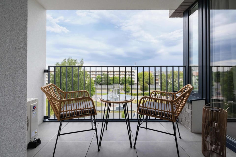 A balcony overlooking green surroundings, equipped with comfortable outdoor furniture, is the perfect spot for morning coffee or evening relaxation.