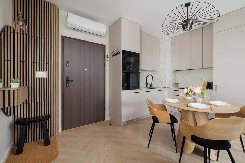 The view from the apartment entrance reveals a neat hallway leading to the bright dining and kitchennette area on the left side.