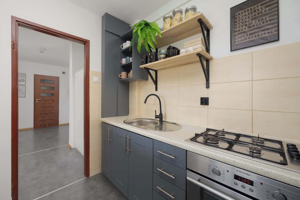 Practical kitchen with gas stove and everything needed for home-cooked meals.